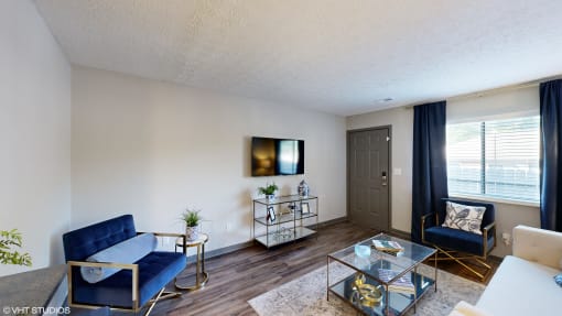 a living room with two blue couches and a glass coffee table at Silvertree at Little Turtle Apartments, Westerville, 43081