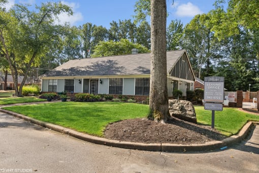 a small white house with a tree in the front yard at The Birches Apartment Homes, Memphis, 38133
