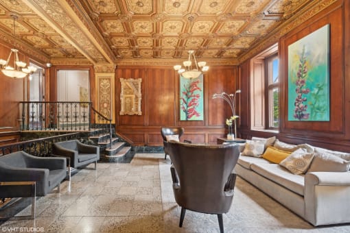 a living room with wood paneling and a seating area with a table and chairs at CWE Apartments, St. Louis, MO, 63108