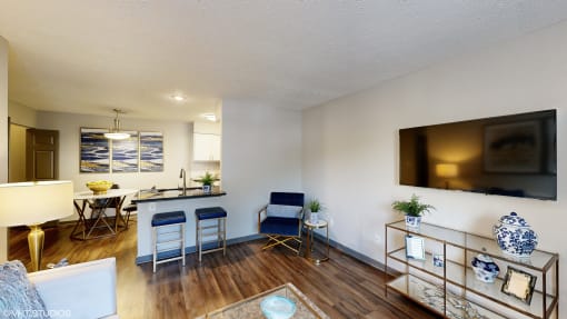 an open living room and kitchen with a table and chairs and a tv at Silvertree at Little Turtle Apartments, Ohio