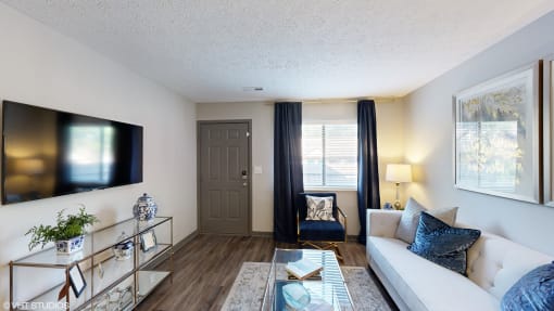 a living room with a white couch and a tv  at Silvertree at Little Turtle Apartments, Westerville, OH, 43081