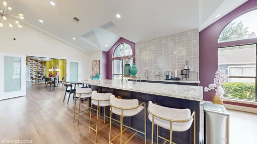 a kitchen with a long counter with bar stools at The Vale Apartments and Townhomes, Cordova, TN