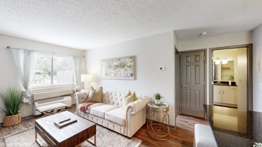 a living room with a couch and a coffee table and a door to a kitchen at Karric Place of Dublin Apartments, Dublin, OH