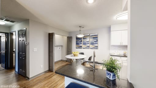 an open kitchen and living room with a large counter top and a sink at Silvertree at Little Turtle Apartments, Westerville, OH