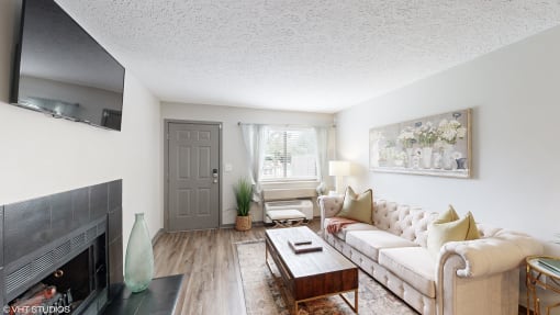 a living room with a couch and a coffee table and a fireplace at Karric Place of Dublin Apartments, Ohio