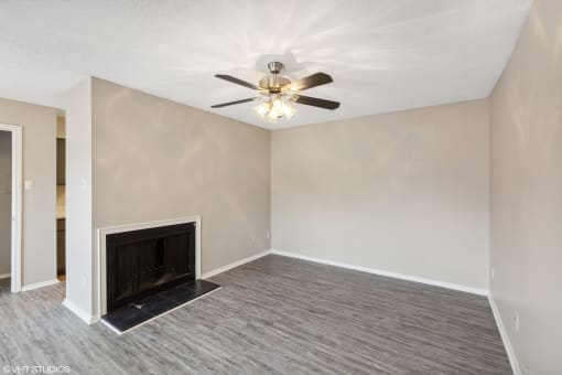 empty room with black fireplace and ceiling fan at The Birches Apartment Homes, Tennessee