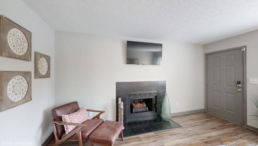 a living room with a fireplace and a chair at Karric Place of Dublin Apartments, Dublin