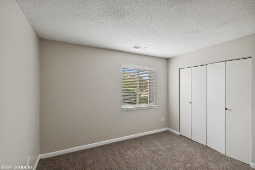 a bedroom with white walls and a window and white closets at The Stella, Memphis, TN, 38134