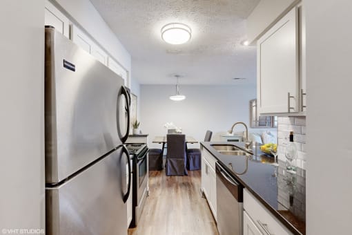 an open kitchen and dining room with stainless steel appliances and white cabinets at Island Club Apartments, Columbus, Ohio