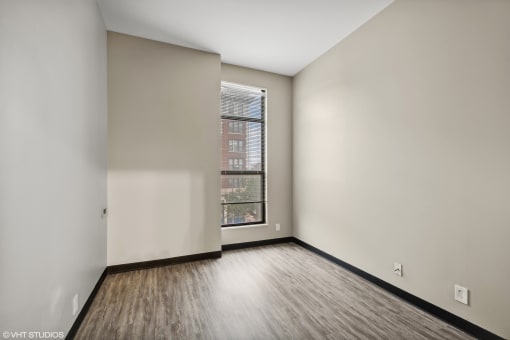 an empty room with white walls and a window at Delmar Loop Apartments, St. Louis