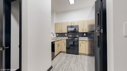 an empty kitchen with wood flooring and wooden cabinets at Bristol On Union Apartment Homes, Memphis, TN, 38104
