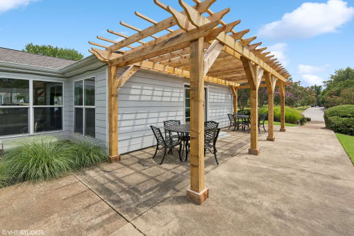 a pergola with a table and chairs on a patio at The Stella, Memphis, TN, 38134