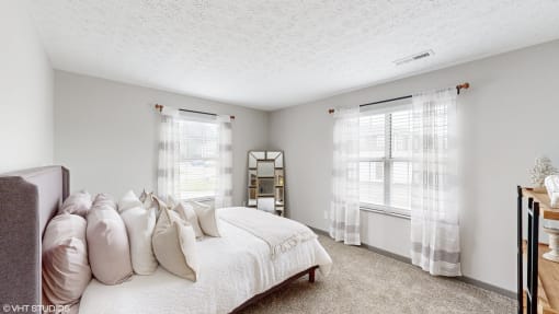 a bedroom with a bed and two windows at Island Club Apartments, Columbus, OH