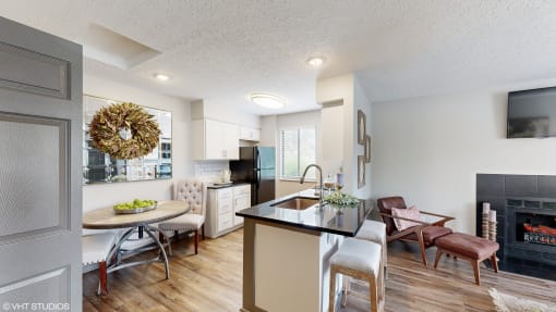 a living room and kitchen with a fireplace and a table with chairs at Karric Place of Dublin Apartments, Dublin, Ohio