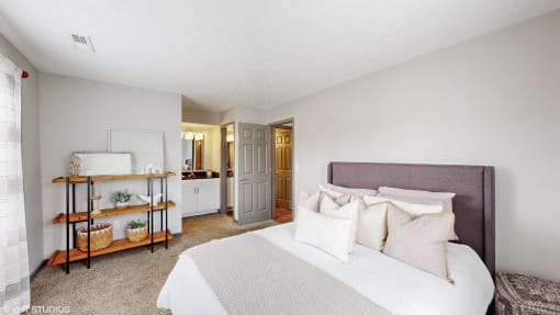 a bedroom with a large bed and a bathroom at Island Club Apartments, Columbus, Ohio