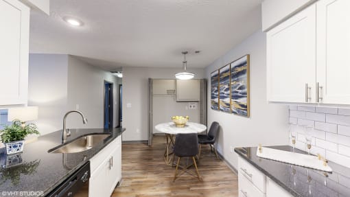 a kitchen and dining room with white cabinets and a table and chairs at Silvertree at Little Turtle Apartments, Westerville, OH