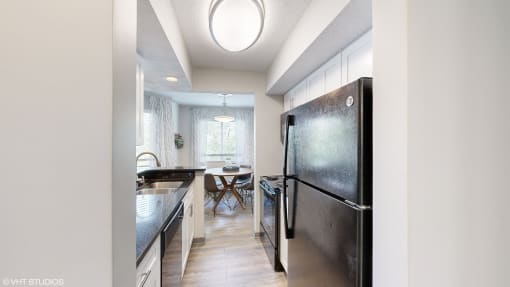 a kitchen with stainless steel appliances and a dining room with a table at Runaway Bay Apartments, Columbus, OH