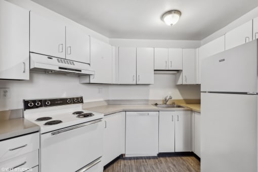 a white kitchen with white appliances and white cabinets at Delmar Loop Apartments, Missouri
