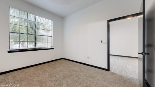 an empty bedroom with a large window and white walls at Bristol On Union Apartment Homes, Memphis