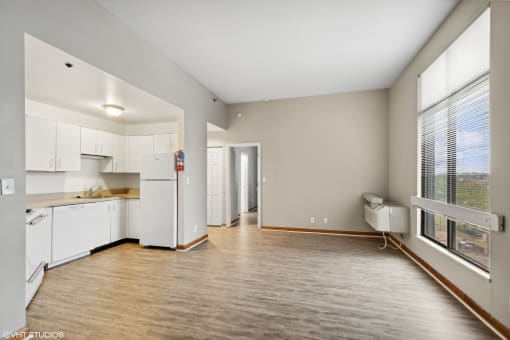 a spacious living room with a kitchen and a large window at Delmar Loop Apartments, St. Louis, Missouri
