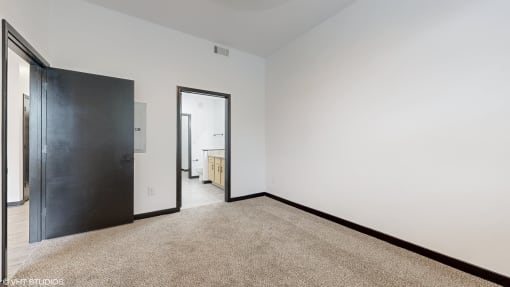 a room with white walls and a black door and a carpet at Bristol On Union Apartment Homes, Memphis
