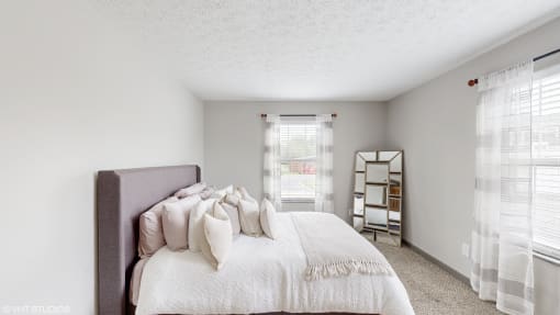a bedroom with a bed and a window and a mirror at Island Club Apartments, Columbus