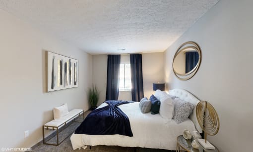 a bedroom with a bed and a mirror on the wall at Silvertree at Little Turtle Apartments, Westerville, Ohio