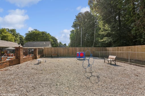 a fenced in backyard with a playground and swings and a bench at The Birches Apartment Homes, Memphis, Tennessee