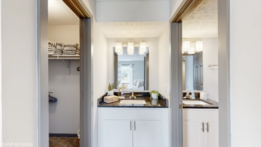 a bathroom with a sink and a mirror and a closet at Island Club Apartments, Ohio, 43235