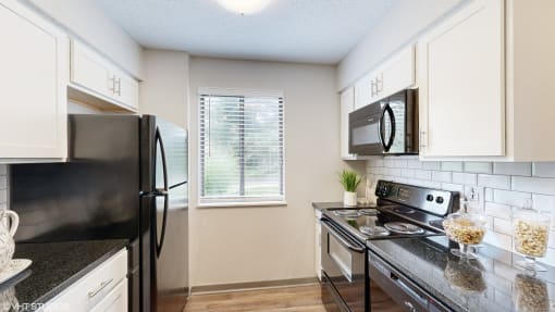 a kitchen with stainless steel appliances and white cabinets at Karric Place of Dublin Apartments, Ohio