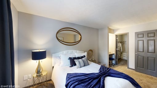 a bedroom with a large bed and a bathroom with a closet at Silvertree at Little Turtle Apartments, Ohio, 43081