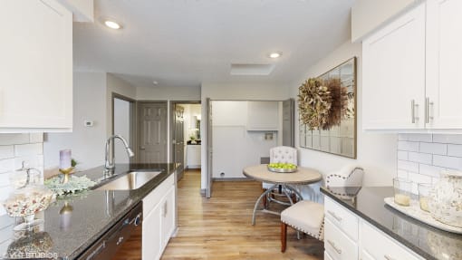 a kitchen and dining room with white cabinets and a table at Karric Place of Dublin Apartments, Dublin, 43016