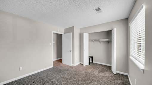 A room with a carpeted floor and a white door. at The Stella Apartments, Memphis