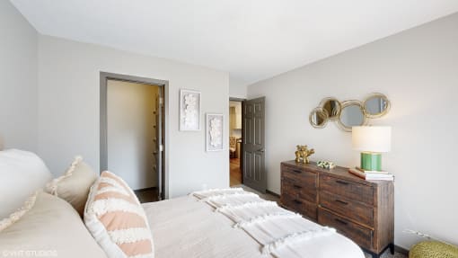 a bedroom with a bed and a dresser and a door to a bathroom at Karric Place of Dublin Apartments, Dublin