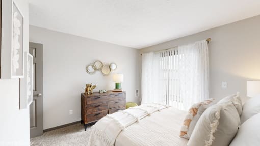 a bedroom with a bed and a dresser and a window at Karric Place of Dublin Apartments, Dublin, 43016