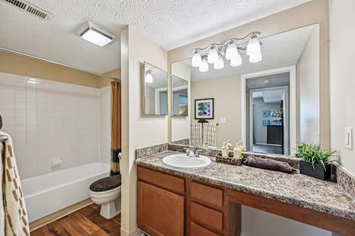 A bathroom with a brown countertop and a white sink.