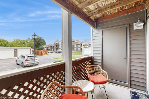 a balcony with two chairs and a door to a parking lot at Island Club Apartments, Ohio, 43235