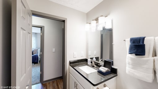 a bathroom with a large mirror and a sink at Silvertree at Little Turtle Apartments, Westerville, 43081