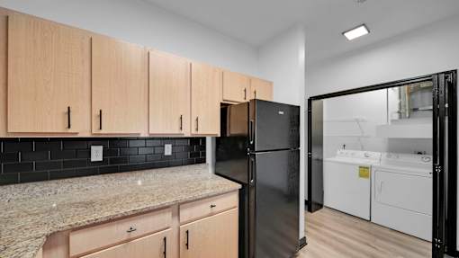 A kitchen with black appliances and wooden cabinets.