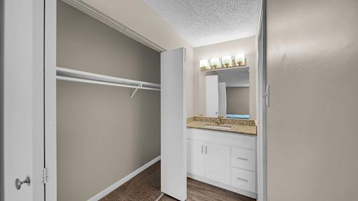 A white bathroom with a sink and mirror. at The Stella Apartments, Memphis, TN