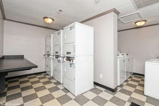 A kitchen with white appliances and a checkered floor at Karric Place of Dublin Apartments, Ohio