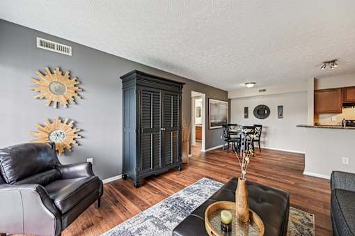 A living room with a black leather couch and a wooden coffee table.
