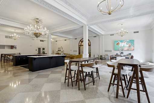 A large, open-plan kitchen and dining area with a checkered floor and wooden furniture.