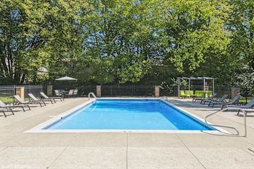 A rectangular pool surrounded by a concrete floor and a fence at Karric Place of Dublin Apartments, Dublin, Ohio