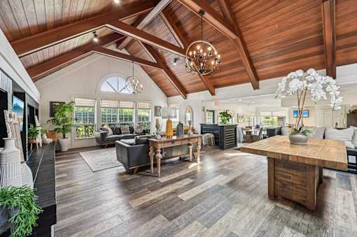 A spacious living room with a wooden ceiling and a large wooden coffee table.