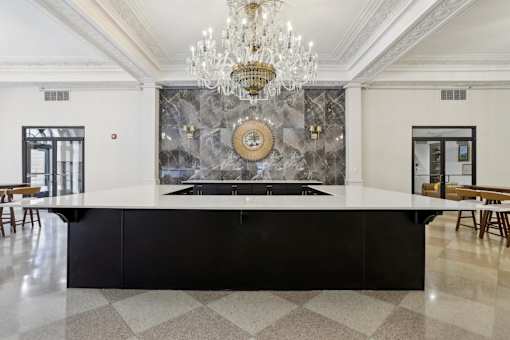 A large, elegant kitchen with a marble backsplash and a chandelier.
