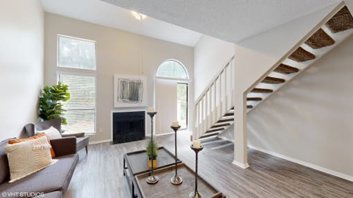 a living room with a staircase and a couch and a table at The Vale Apartments and Townhomes, Cordova, TN