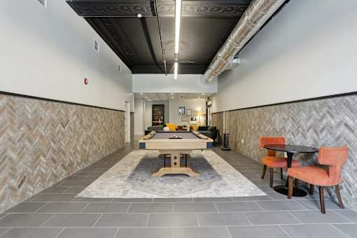 A long hallway with a table and chairs at the end.