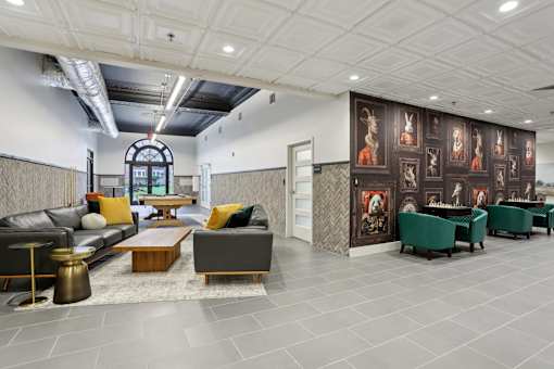 A modern living room with a grey sofa, a coffee table, and a large painting on the wall.