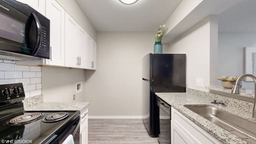 a kitchen with black appliances and granite counter tops at The Vale Apartments and Townhomes, Tennessee